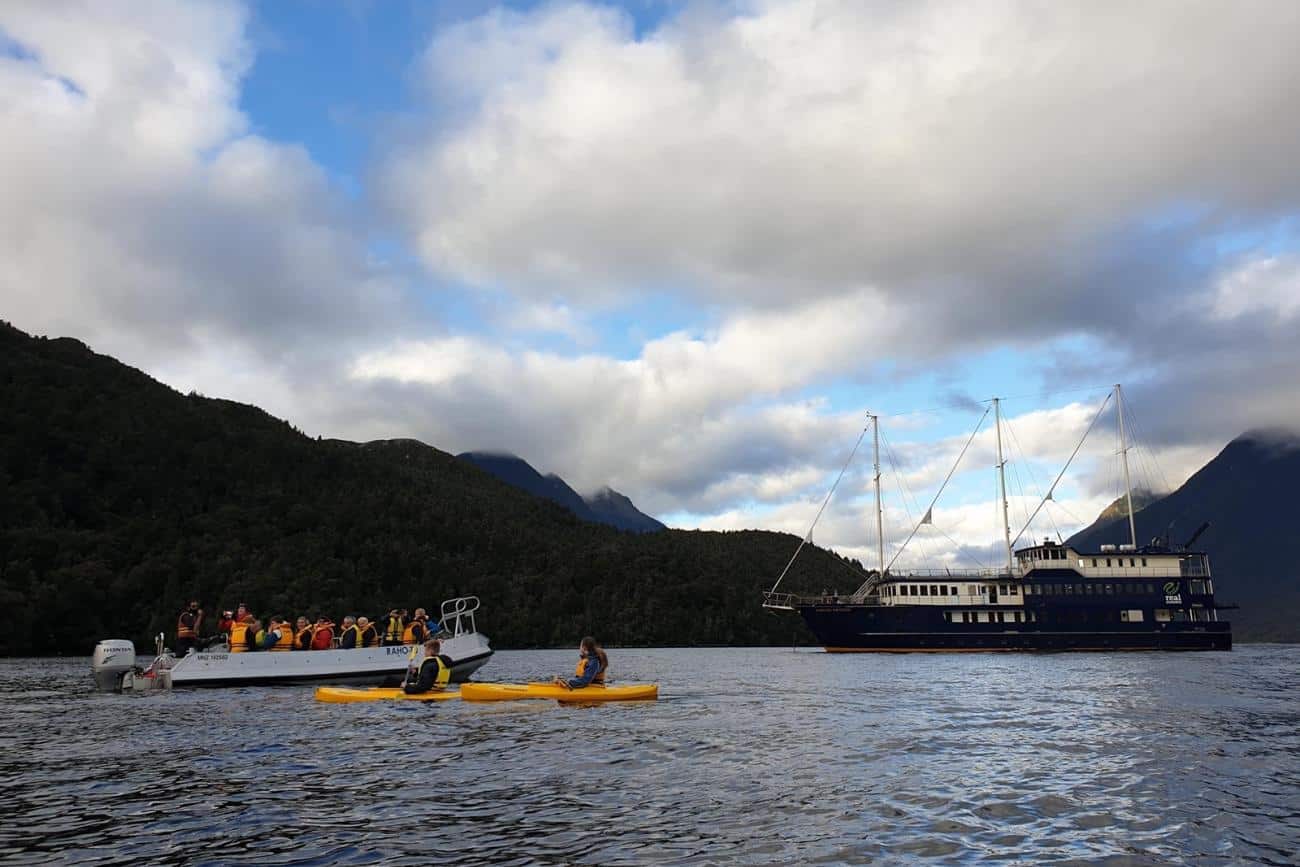 Kayakers and tender boat on Doubtful Sound