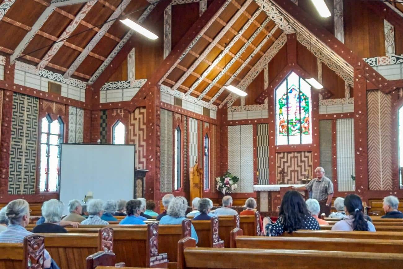 Guide explaining about St Mary's church in Tikitiki, showing interior of church